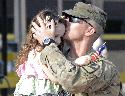Capt. Merlin Dupont, Administrative officer-in-charge, Headquarters and Headquarters Battalion, 1st Cav. Div., kisses his daughter, April 6, at Cooper’s Field, after returning from a year deployment to Afghanistan in support of OEF XII.