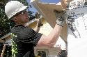 1st Lt. Brad Fisk, fire direction officer for 2nd Platoon, Battery B, 3rd Battalion, 82nd Field Artillery Regiment, 2nd Brigade Combat Team, 1st Cavalry Division, places a sheet of soffit to form the eaves of a Habitat-for-Humanity home in Jarrell, Texas, July 26 as part of a volunteer opportunity coordinated by the Fort Hood Women's Mentorship Network. 