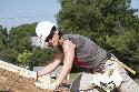 Maj. Heather Gunther, S-6 for 3rd Brigade Combat Team, 1st Cavalry Division and co-founder of the Fort Hood Women's Mentorship Network, slides a sheet of plywood into place to form the roof of a Habitat-for-Humanity home in Jarrell, Texas, July 26.